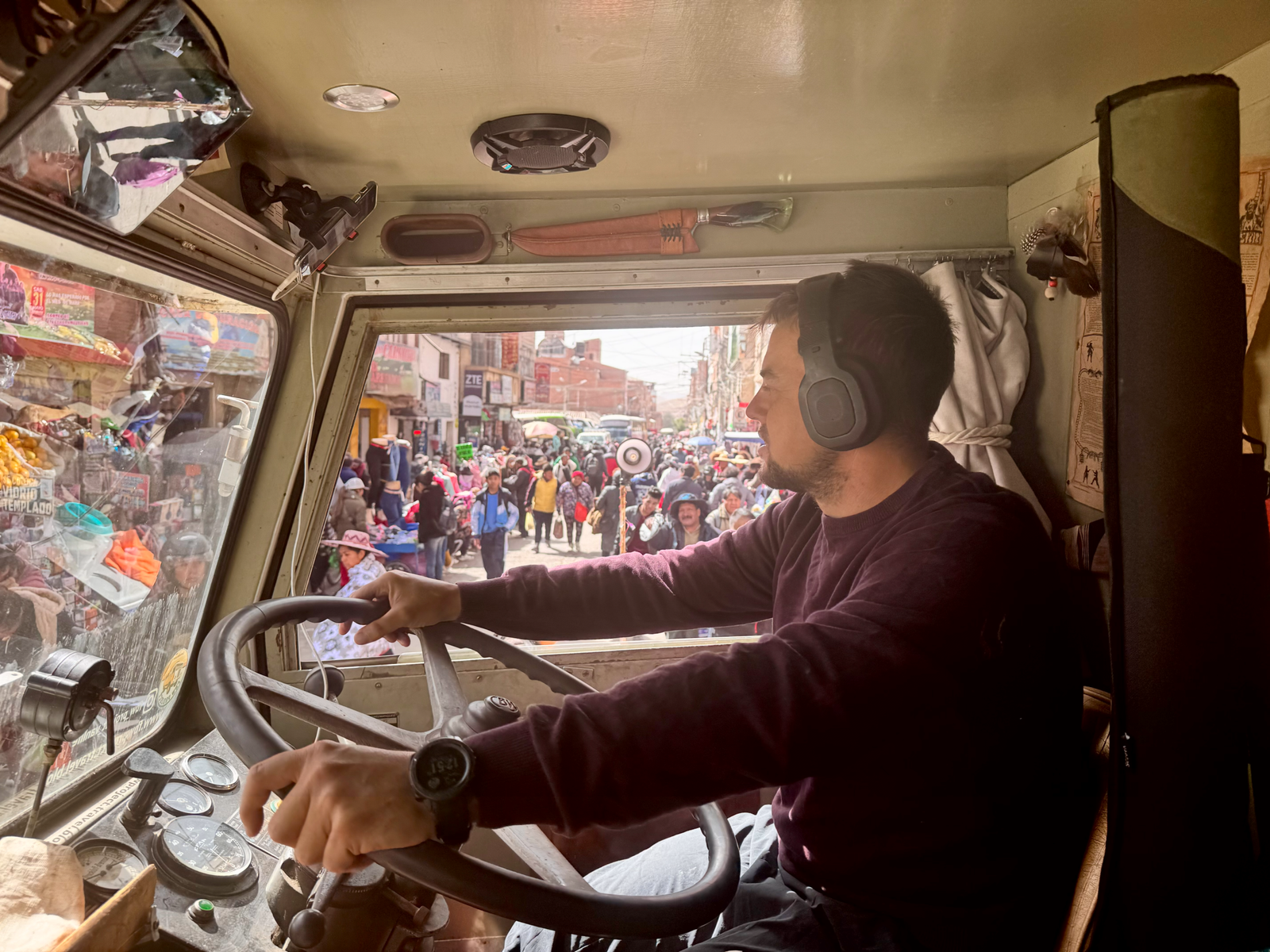 Vue depuis la cabine de Woody, au volant, dans une rue de marché bondée